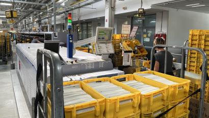 Bild: DHL Group/exb
Eine Mitarbeiterin im Briefzentrum in Amberg sortiert die Wahlunterlagen.