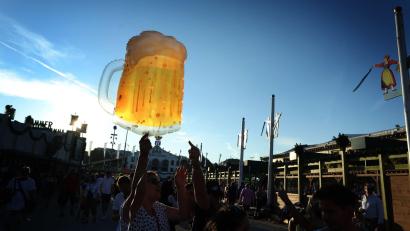 Bild: Karl-Josef Hildenbrand/dpa
Oktoberfestbesucher halten im Abendlicht einen Luftballon in Form eines Maß Kruges.