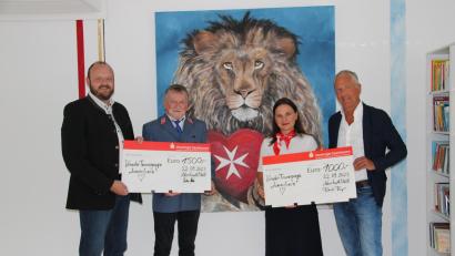 Bild: prh
Kinderarzt Roland Renz (rechts) und Landrat Andreas Meier (links) übergeben vor dem Löwenbild mit Malteserherz symbolische Spendenschecks über 1000 Euro an Johanna Lakomski (Zweite von rechts) und 1500 Euro an Dieter Landgraf (Zweiter von links) für die Kinder-Trauergruppe "Löwenherz".