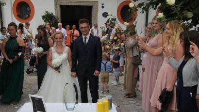 Bild: kro
Ein farbenprächtiges und buntes Ehrenspalier gab es für Anke Zimmermann und Alexander Wunderlich. Am Kappl-Vorplatz musste das Paar ein Stoffherz ausschneiden, außerdem waren die Zutaten für ein Sand-Ritual aufgebaut.