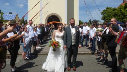 Bild: bk
Strahlend ins Eheglück: Julian und Lena Kraus beim Durchschreiten des Ehrenspaliers.