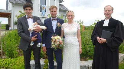 Bild: bk
Jonas und Anna Wurzer vor ihrem 2018 bezogenen Eigenheim mit dem soeben getauften Söhnchen Paul auf dem Arm des Paten Elias Wurzer und Pfarrer Matthias Weih.