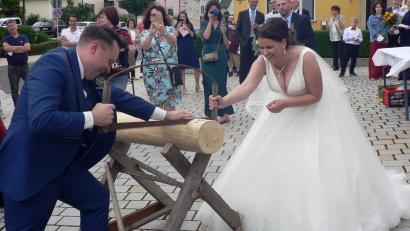 Bild: lep
Viele Aufgaben hatte das junge Paar nach der kirchlichen Trauung zu bewältigen. Begleitet mit der Quetschen mussten sie mit einer stumpfen Säge versuchen, den Baumstamm zu durchtrennen. In Teamarbeit und am Ende mit der Motorsäge klappte dies auch.