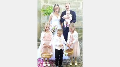 Bild: lep
Sonne und Brautpaar strahlen, die Freunde und Vereinskollegen bilden ein ansehnliches Hochzeitsspalier, die Brautmädchen und der -junge streuen Blumen, als Franziska und Michael Wildenauer mit Töchterchen Alisa nach der Trauung die Bergkirche verlassen.