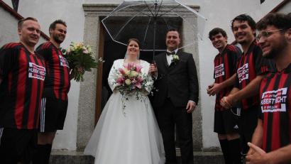 Bild: kro
Von den Fußballern der DJK Falkenberg wurden Andrea und Peter Lindner im Ehrenspalier erwartet. Gegen den leichten Regen schützte ein Regenschirm.