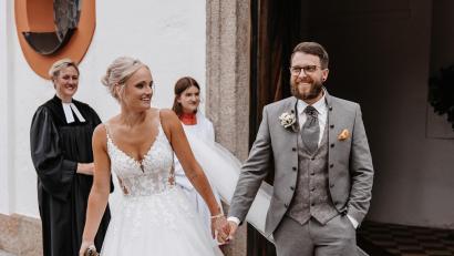 Bild: Julian Bächer Photography/exb
Beim Verlassen der Kappl strahlen Carina und Florian Zimmert vor Glück. Hinten links die evangelische Pfarrerin Dr. Stefanie Schön.