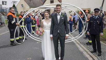 Bild: bk
Andreas und Carina Luber schreiten durchs Rosen- und Schlauchspalier ins Eheglück.