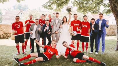 Bild: Lena Härtl/exb
Das Brautpaar Sarah und Florian Burger zusammen mit den ASV-Fußballern nach der Trauung in Plößberg.