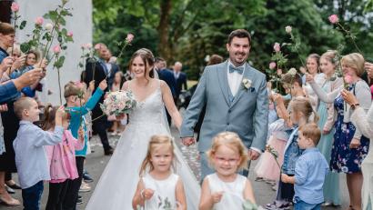 Bild: Jennifer und Thorsten Photography
Sandrina und Julian Reil schreiten nach der Trauung durch ein Blumenspalier.