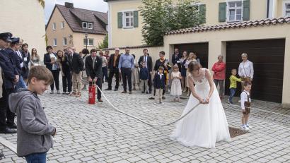 Bild: fpoz
Corinna und Florian Wegmann mussten nach der Trauung ihre Geschicklichkeit beim „Löschangriff“ mit der kleinen Handspritze beweisen.