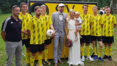 Bild: dob
Die Fußballer des SV Waldau überraschen Eva und Daniel Wolfrath mit Söhnchen Max nach der Trauung.