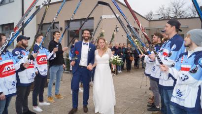Bild: du
Christian Wolf und seine Frau Mareike schreiten nach ihrer standesamtlichen Hochzeit vor Bürgermeister Ernst Lenk im Schirmitzer Bürgersaal durch ein langes Gratulationsspalier von Freunden und Bekannten sowie den Eishockey-Spielern des EV Weiden.
