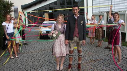 Bild: wro
Das Spalier mit bunten Bändern bildeten Freunde, die Clarissa und Sven Seidel vor der Mehrzweckhalle erwarteten, um das frisch vermählte Paar hochleben zu lassen.