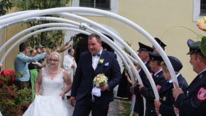 Bild: sis
Yvonne und Roland Schmid schreiten durch das Spalier, hinten links an der Kirchentür Peter Bublitz, Diakon und Vater der Braut.