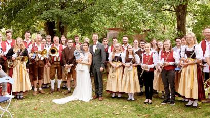 Bild: amö
Das Brautpaar mit Tochter Ida inmitten der Blaskapelle