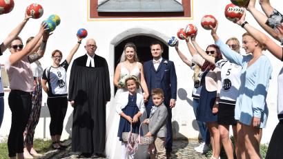 Bild: no
Das frisch vermählte Paar schreitet, beobachtet von Pfarrer Thomas Schertel, durch das Spalier der Damenmannschaft des Handballclubs Sulzbach-Rosenberg.