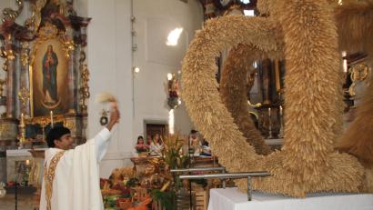 Bild: frd
Nach dem Gottesdienst segnet Kaplan Chinna Chennaiah Dola die von der Dorfgemeinschaft Eigelsberg/Niesaß vor dem Altar platzierten Feldfrüchte. Rechts im Bild die vom Obst- und Gartenbauverein Oberviechtach gefertigte Erntekrone.