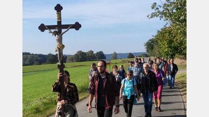 Bild: Wulfänger/exb
Jonas Hofmann und Katja Schönberger führen die Wallfahrer an, die sich von Schirmitz aus auf zum Fahrenberg machen. Abwechselnd tragen sie das Pilgerkreuz.