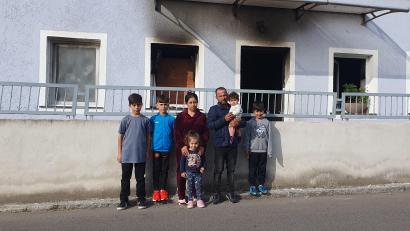 Bild: Stefanie Schreyer/exb
Familie Bilasini , Vater Wisam, Ehefrau Sahira, die fünf Kinder Hedel, Vidl, Aydil, Elina und die acht Monate alte Alina, steht vor dem rußgeschwärzten Eingang ihres mühevoll restaurierten Eigenheims, das durch den Band jetzt unbewohnbar ist. .
