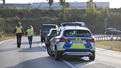 Bild: Sven Hoppe
Polizisten gehen in der Nähe der Unfallstelle. Beim Unfall eines mutmaßlichen Schleuserfahrzeugs auf der Autobahn 94 sind sieben Menschen gestorben und mehrere schwer verletzt worden.