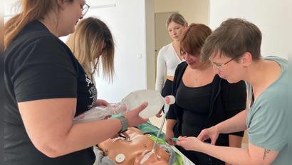 Bild: Peggy Kuniss-Pfeiffer/exb
Die Patienten-Puppe bleibt geduldig, wenn viele Hände an ihr üben: Denn bei der Notfallhilfe muss jeder Handgriff sitzen. Grundlagen ihres Wissens wollen die Kursteilnehmer in einem Film weitergeben, damit im Ernstfall jeder eingreifen kann.