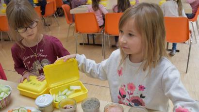 Bild: ubb
Albina und Pia (von links) schlichten ihre neuen Biobrotzeitboxen mit Biolebensmitteln aus der Region voll. Die beiden Mädchen mögen fast alles, was auf dem Frühstückstisch für Grundschulkinder vorbereitet wurde und greifen zu.