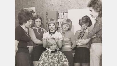 Bild: Studio Weiden Friseurschule
Es war die Zeit der kurzen Röcke, der Plateau-Sandalen, der bunten Muster und der Pony-Frisuren: 1973 wurde die Friseurschule Müller gegründet. Heuer feiert sie 50. Geburtstag. Das Bild zeigt eine Ausbildungssituation für Meisterschüler in der Anfangszeit. An der Frisur arbeitet Elisabeth Müller.