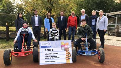 Bild:  Mariella Kramer/exb
Voller Stolz präsentierten die Rupert-Egenberger-Schüler ihre neue Kettcar-Bahn. Zur Spendenübergabe waren gekommen: „Allianz für Kinder in Bayern“-Geschäftsführerin Châu Báu Tang-Rupp (links) sowie die lokalen Projektpaten. Sie überreichten den Scheck an Erlebnis- und Ergotherapeut Thomas Ertel (Vierter von rechts), der die Gäste gemeinsam mit Schulleiter Michael Schuierer (Dritter), Fachbereichsleiterin der Heilpädagogischen Tagesstätte, Juliana Schweitzer, Lebenshilfe-Geschäftsführerin Katrin Panek und den Schülern empfing.
