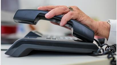Symbolbild: Jan Woitas/dpa
Eine Mitarbeiterin der Telefonseelsorge nimmt einen Telefonhörer an ihrem Arbeitsplatz in die Hand.