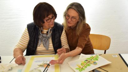 Bild: ubb
Kursleiterin Hanne Heck (rechts) zeigt Johanna Maurer, wie die Augen eines Vogel mit Aquarellfarben richtig gemalt werden.
