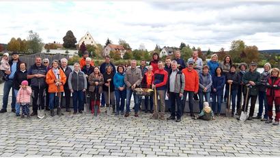 Bild: Stadt Tirschenreuth/exb
Bürgermeister Franz Stahl mit Helmut Wolfrum, Regionalmarktleiter des Volksbank Raiffeisenmarkt Nordoberpfalz, sowie Vinzenz Rahn (vorne Mitte) und den vielen Helfern der diesjährigen Herbstpflanzaktion.