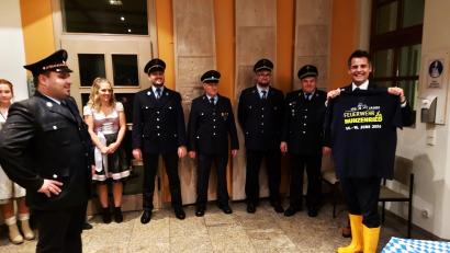 Bild: lg
Der Nunzenrieder Feuerwehrvorstand Martin Ruhland (links) stattet den Bürgermeister mit den nötigen Schirmherrn-Utensilien aus: Bayernschirm, Stiefel und T-Shirt.