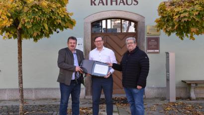 Bild: Stadt Schönsee/exb
Bürgermeister Reinhard Kreuzer, Wolfgang Dumm vom Bayernwerk, Geschäftsleiter Matthias Jeitner (von links) halten einen Laternenkopf mit den sparsamen LED in den Händen.