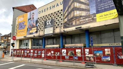 Bild: Gabi Schönberger
Ein roter Bauzaun mit Bildern der Stadt dient künftig als Sichtschutz für das von Taubendreck verunstaltete Weidener Josefshaus.
