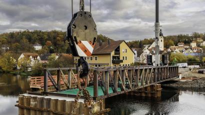 Bild: Hösamer
Der erste Teil der Behelfsbrücke über die Naab von der Schwandorfer Wöhrvorstadt in Richtung Krondorf wird sein Anfang dieser Woche eingehoben und montiert.