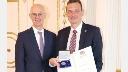 Bild: Regierung der Oberpfalz/Stühlinger-Weinhändler
Ernst Schicketanz (rechts), Bürgermeister von Altenstadt/WN, wird von Regierungspräsident Walter Jonas mit der Kommunalen Verdienstmedaille ausgezeichnet.
