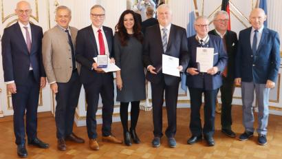 Bild: Regierung der Oberpfalz/Stühlinger-Weinhändler/exb
Regierungspräsident Walter Jonas und Landrat Roland Grillmeier (von links) gratulieren Bernd Sommer (Dritter von links), Hilmar Wollner (Vierter von rechts) und Friedrich Holm (Dritter von rechts) zur Ehrung. Erste Gratulanten waren Bürgermeisterin Margit Bayer aus Waldershof, Bürgermeister Toni Dutz aus Wiesau (Zweiter von rechts) und Zweiter Bürgermeister Karlheinz Hoyer (rechts) aus Waldsassen.