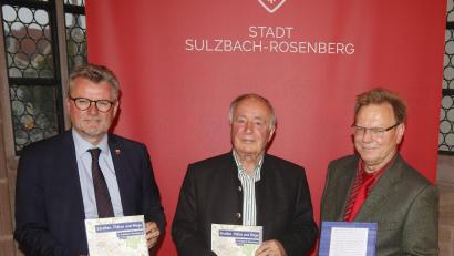 Bild: mfh
Autor Dr. Adolf Rank (Mitte) im Jahre 2021 mit Bürgermeister Michael Göth (links) und Stadtarchivar Johannes Hartmann bei der Präsentation des letzten großen Werks von Adolf Rank, „Straßen, Plätze und Wege in Sulzbach-Rosenberg“, das die Stadtgeschichte in einem anderen Kontext zeigt.
