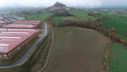 Bild: bey
Die freie, bräunlich erscheinende Fläche wird bis zur oben zu sehenden Baumreihe für eine Erweiterungsbau der Firma Witron genutzt, Das neue Gebäude erhält zwei Verbindungen zum linken größeren Betriebsgebäude.