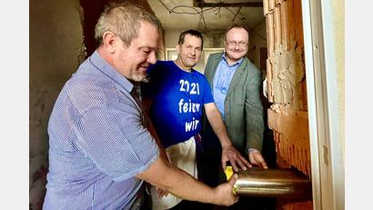 Bild: Krones
Stecken die Metallkapsel mit der Urkunde in das bestehende Grundsteinloch (von links): Projektleiter Reinhard Seidl, Marktrat Stefan Blind und Bürgermeister Uwe König.