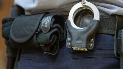 Bild: Friso Gentsch/dpa/Symbolbild
Handschellen stecken in der Gürtelhalterung eines Justizbeamten.