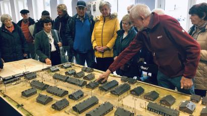 Bild: wro
In den Mittelpunkt beim Besuch einer Delegation aus Augsburg und Mittelfranken rückte das Modell des ehemaligen Grenzdurchgangslagers in Wiesau. Die Details erläuterte der Wiesauer Historiker Adalbert Busl (rechts). Zu den vielen, die dort lebten, gehört auch Anita Donderer aus Augsburg (Zweite von links).