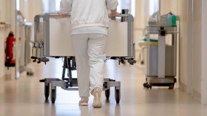 Bild: Marijan Murat/dpa
Eine Krankenpflegerin schiebt ein Krankenbett durch einen Flur. In der Pflegebranche sind weiter viele freie Stellen gemeldet.