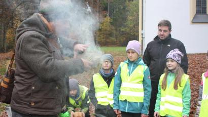 Bild: Steffi Igl / FFW Rieden
Gleich brennt der Zunder: Naturpark-Ranger Christian Rudolf erklärt dem Riedener Feuerwehrnachwuchs das Feuermachen mit Naturmaterial.