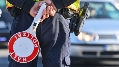 Bild: Patrick Pleul/dpa-Zentralbild/ZB/Symbolbild
Ein Polizeibeamter hält eine Winkerkelle in den Händen.