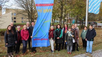 Bild: Prechtl/LAA Schwandorf/exb
Landrat Thomas Ebeling und Kooperationsbeteiligte hissen am Landratsamt die Flagge zum Gedenktag „Nein zu Gewalt an Frauen“.