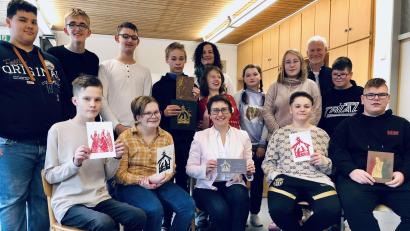 Bild: Mariella Kramer/exb
Von der Schulbank ins Parlament: Die Schüler der Klasse 8a überreichten mit Schulleiter Michael Schuierer und Konrektorin Nadine Heldrich die 600 in Auftrag gegebenen Weihnachtskarten an Bundestagsabgeordnete Susanne Hierl.