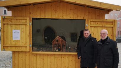 Bild: u
Neben dem Christbaum auf dem Marktplatz ist in einem Marktstand bis zum 6. Januar 2024 täglich von 8 bis 20 Uhr eine von Stadtrat Martin Merkl (links) organisierte und von Josef Kohl bestückte Krippenausstellung zu besichtigen.