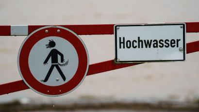 Bild: Andreas Arnold/dpa/Symbolbild
Ein Hochwasser-Schild steht an einem überfluteten Feld.