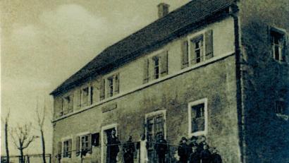 Bild: Archiv Werner Veigl/exb
Die älteste erhaltene Fotografie des Gasthauses Veigl aus den Jahren vor 1919 stammt aus einer Ansichtskarte im Privatarchiv von Werner Veigl. Stolz präsentiert sich die ganze Wirtsfamilie mit (von links) Wirt Johann Veigl (1868 bis 1919), Ehefrau Margareta (1880 bis 1970) und Josef Veigl (1902 bis 1943, Vierter von links) mit weiteren Kindern der Familie.